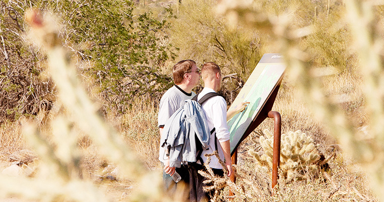 Two hikers studying a trail map in the preserve