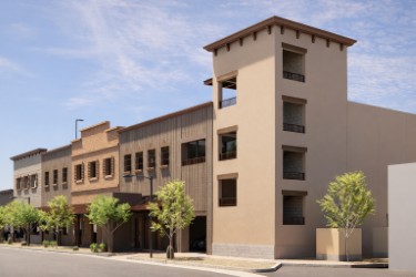 Modern three-story mixed-use building with stucco and vertical metal siding along a tree-lined city street.