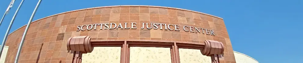 Exterior view of Scottsdale Justice Center with its name displayed in large letters on the building's facade, under a clear blue sky.