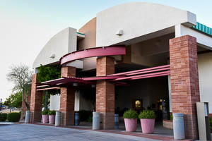 Via Linda Senior Center entrance with brick columns, curved awnings, and large decorative planters.