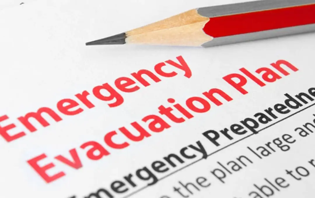 Close-up of an emergency evacuation plan document with a pencil resting above it.