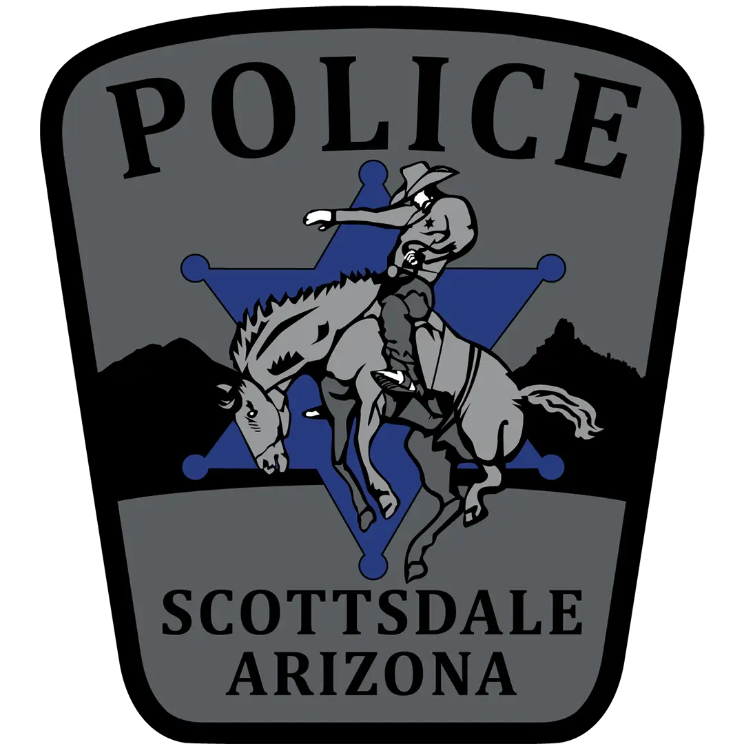 Scottsdale Police badge featuring a rider on a horse centered over a blue star, with “POLICE” above and “SCOTTSDALE ARIZONA” below on a gray shield-shaped background.