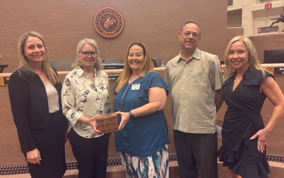 Five people pose with an award in front of a City of Scottsdale Arizona seal.