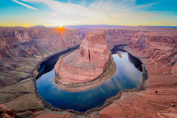 Sunlit view of Horseshoe Bend with the river curving around a large rock formation